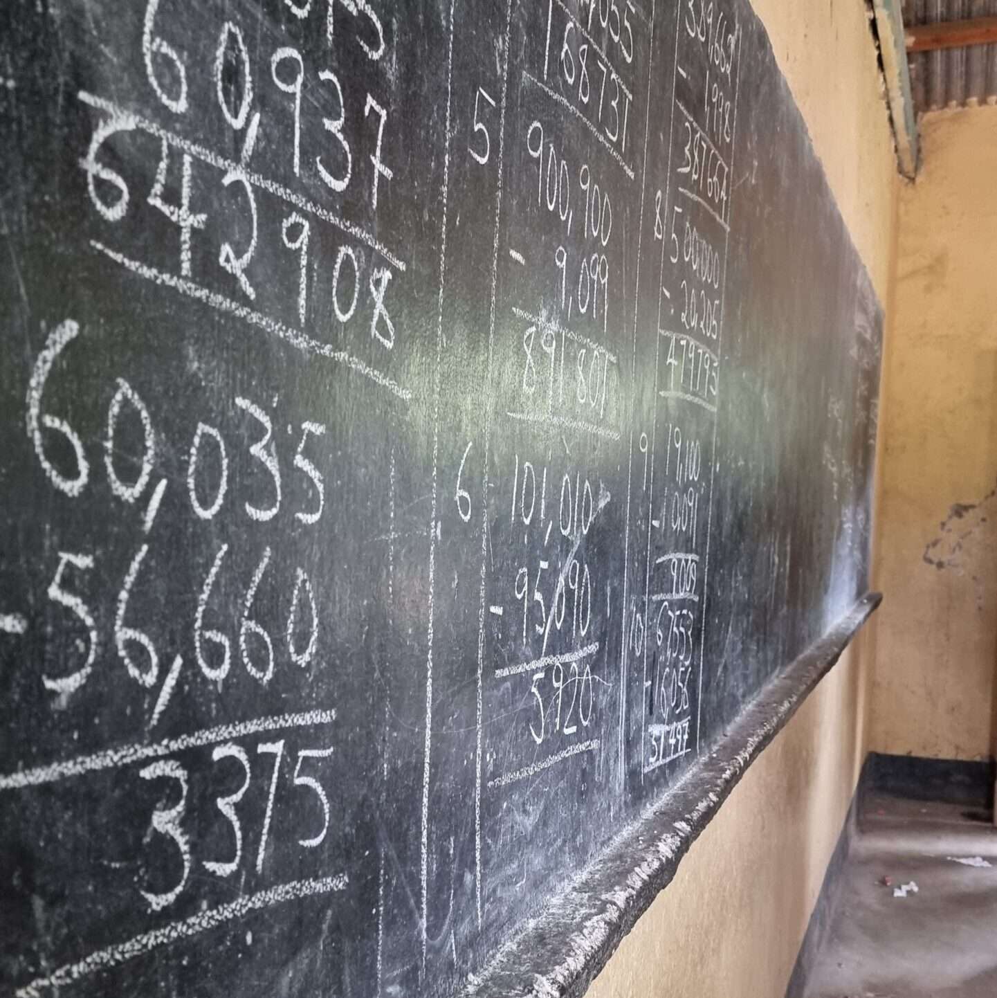 Tableau d'école de la classe, avec des calculs mathématiques écrits à la craie.